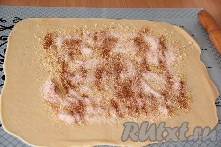 Посыпать пласт теста панировочными сухарями, затем - 1/2 сахара и 1/2 корицы, нужных для приготовления начинки. Края теста оставить пустыми.
