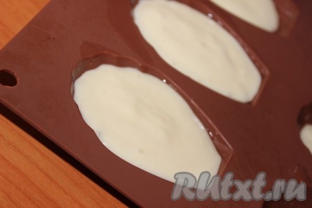 Неглубокие силиконовые формочки (я взяла силиконовую форму для выпечки печенья "Мадлен") немного смазать растительным маслом. Разложить тесто по формочкам, заполняя их на 2/3 объёма. Можно приготовить это печенье и в формочках для кексов, маффинов, только выкладывать в такие формочки нужно по 2 чайных ложки теста.