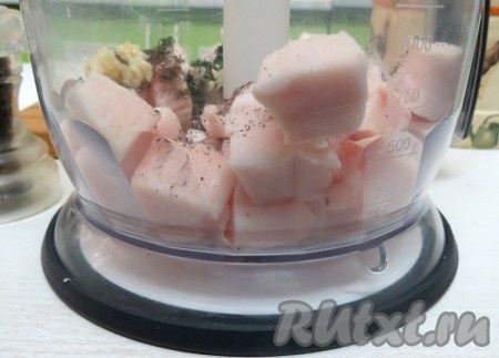 Половину сала вкладываем в комбайн. Туда же отправляем несколько зубчиков чеснока, выдавленных через пресс, перец горошком, предварительно перемолотый в мельнице. Свежий перемолотый перец добавляет невероятный аромат (если нет мельницы, добавьте чёрный молотый перец). Отправляем в чашу комбайна несколько веточек мелко нарезанного укропа. Повторяю, сало нарезать нужно на маленькие кусочки, тогда они быстрее и легче перемалываются.
