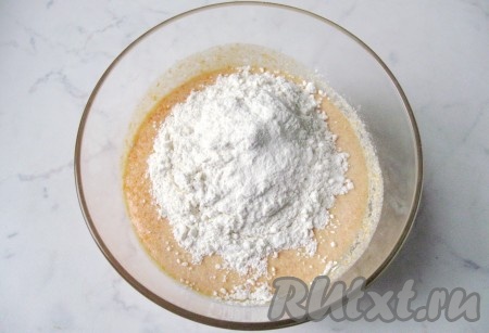 Всыпать в миску соду, погашенную уксусом, и 150 грамм муки, перемешать тыквенное тесто лопаткой до однородности.