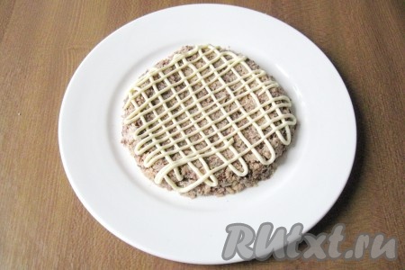 Нанести на консервы сеточку из майонеза.
