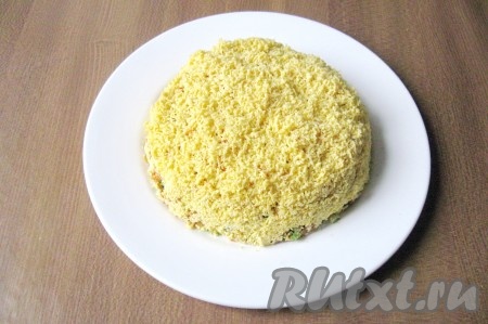 Желтки помять вилкой или натереть на терке.  Покрыть весь салат измельченными желтками.
