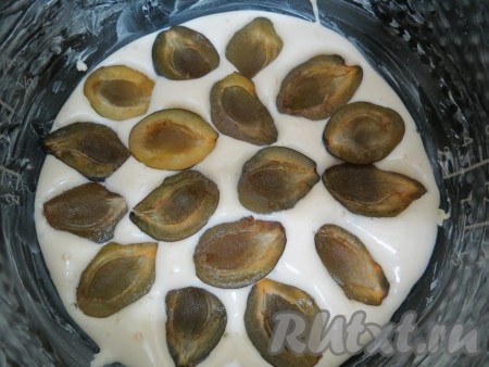 На дно формы наливаем тоненький слой теста, только чтобы закрыть дно. На него выкладываем сливы, разрезом вверх, и слегка их прижимаем.
