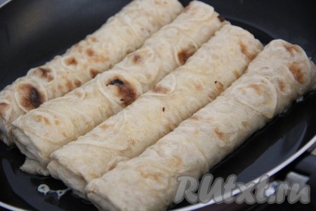 Сковороду смазать растительным маслом и хорошо разогреть. Выложить рулетики из лаваша с сыром в сковороду.
