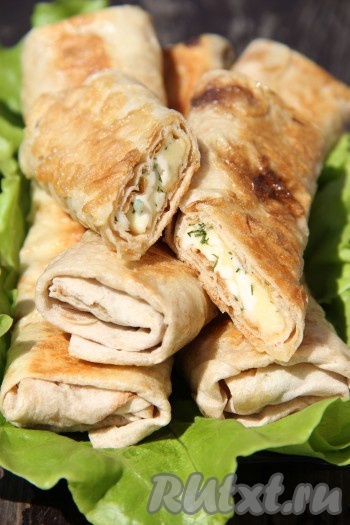 Затем переложить рулеты на тарелку. Постепенно пожарить на сковороде все рулетики. Аппетитные, вкусные, достаточно сытные рулетики из лаваша с сыром подать к столу в горячем виде. Кстати, и в холодном виде они тоже хороши. Лаваш прекрасно сочетается с сыром и зеленью, поэтому такая закуска - беспроигрышный вариант.