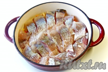 Поверх овощей выложить кусочки рыбы, посолить и поперчить по вкусу.
