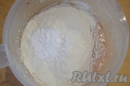 В полученную массу просеять муку с разрыхлителем, перемешать (или взбить). Тесто для кексов с малиновым вареньем должно плавно стекать с ложки.
