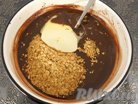 Подготовленную шоколадную массу поставить на средний огонь, постоянно помешивая венчиком, довести до кипения, огонь убавить до минимального. Сразу добавить измельчённые орехи и сливочное масло.