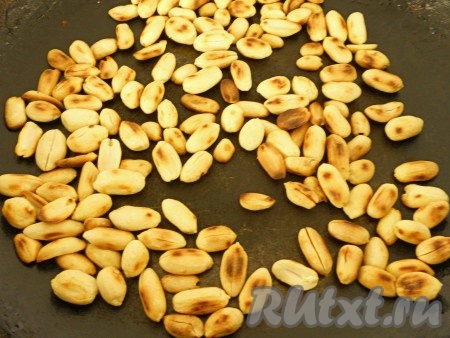 Очищенные орехи (у меня - арахис, но можно взять, например, и грецкие) поджарить на сухой сковороде, помешивая, на среднем огне.