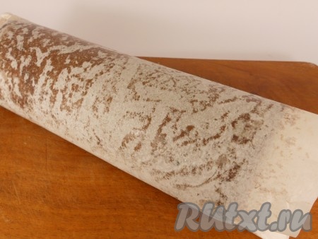 Корж немного остудить и свернуть его вместе с пергаментом. Оставить до полного остывания.