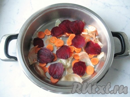 Морковь и свёклу почистить, помыть и нарезать кружками. Шелуху с одной большой или двух средних луковиц помыть. Дно широкой кастрюли выложить луковой шелухой, кружками моркови и свёклы.
