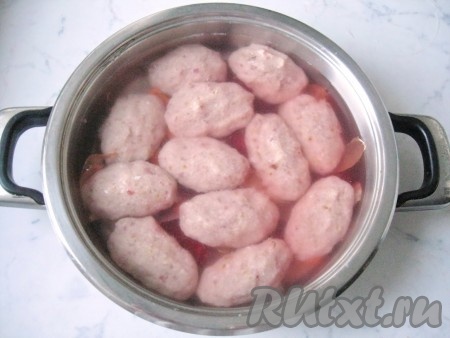 Осторожно по стенке кастрюли, чтобы не размыть тефтели, налить воду. Она должна покрывать рыбу полностью.  Посолить и поперчить по вкусу, добавить сахар. Поставить на плиту. Довести до кипения и огонь уменьшить до минимума. Через час  добавить лавровый лист и налить еще 300 мл воды. 
