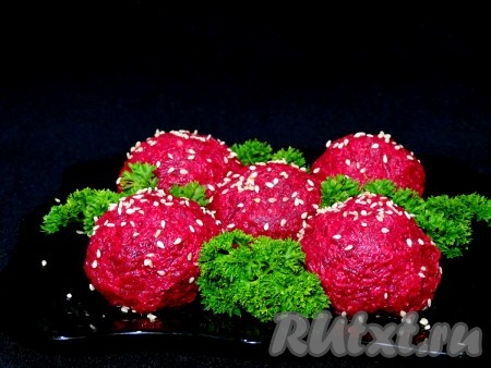 Аналогично формируем все закусочные свекольные шарики с селёдкой, выкладываем на тарелку, украшаем зеленью, посыпаем кунжутом. Аппетитная, яркая, вкусная закуска из свеклы и сельди станет украшением не только повседневного, но и праздничного стола.