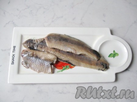 Отрезать голову и плавники у селёдки, снять кожу. Из брюшка удалить внутренности и чёрную плёнку, промыть сельдь водой. Разрезать рыбу вдоль по хребту, удалить хребет и кости. Вы получите в итоге филе. У меня вес филе составил 400 грамм. Можно сразу купить готовое филе сельди.