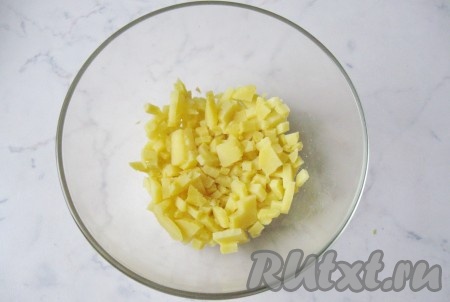Картофель сварить в "мундире" до готовности, пока в него не будет свободно входить вилка. На это потребуется от 30 до 50 минут, в зависимости от размера картофеля и его сорта. Охладить, почистить и мелко нарезать.
