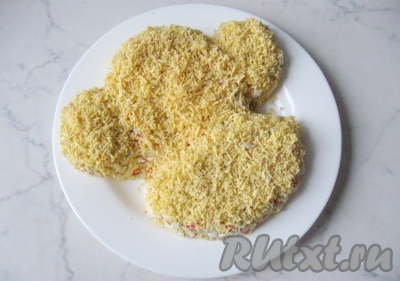 Желтки от яиц натереть на тёрке и выложить ими весь салат.
