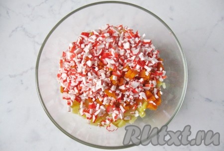 Крабовые палочки мелко нарезать. Добавить к картофелю и моркови.
