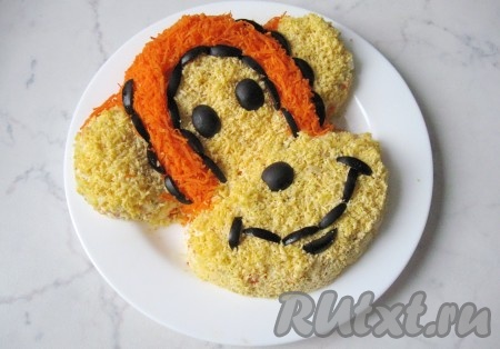 Из половинок маслин сделать глаза и носик обезьяны.  Каждую маслину разрезать на тонкие полоски и выложить ими  рот обезьянки и контуры волос. 
