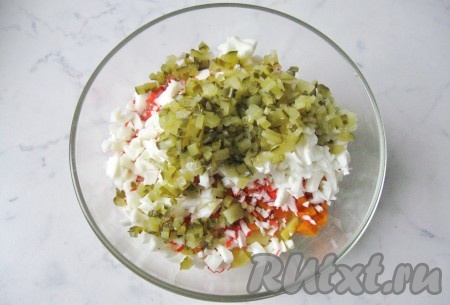 Маринованный или соленый огурец мелко нарезать, выложить в салатник.
