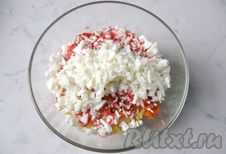 Яйца выложить в кастрюлю, залить холодной водой и варить 10 минут. После охладить и почистить. Отделить белки от желтков. Белки мелко нарезать, добавить в салат.
