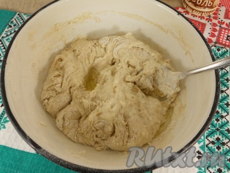 Продолжать замешивать тесто вначале ложкой, а потом руками.
