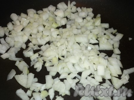 На сковороде разогреть растительное масло, выложить очищенный и мелко нарезанный лук, обжарить его на среднем огне, иногда помешивая, в течение 5 минут.