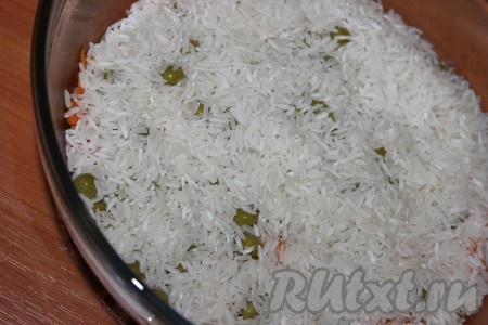 Рис тщательно промыть под проточной водой, добавить к луку, моркови и горошку. Посолить, поперчить.
