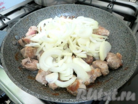 К обжаренной свинине выкладываем лук, перемешиваем.