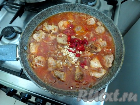 Перец, чеснок, специи, соль добавляем к свинине в томатном соке, хорошо перемешиваем, закрываем сковороду крышкой и тушим мясо на небольшом огне минут 45 (до мягкости свинины), иногда перемешивая.