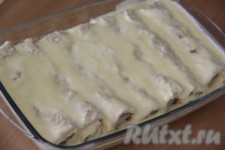 Вылить получившуюся смесь поверх рулетиков из лаваша с творогом. Поставить форму в разогретую духовку и запекать при 200 градусах, примерно 30 минут, до золотистой корочки.