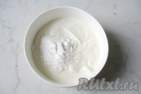 Сметану выложить в миску, добавить сахарную пудру. Аккуратно перемешать.
