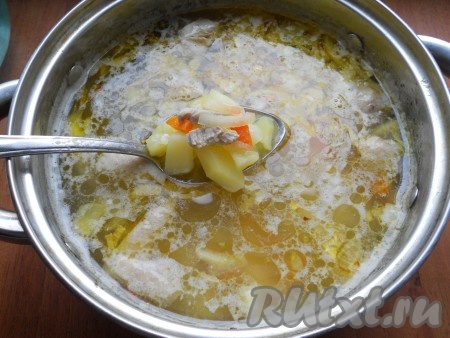 В кастрюлю с бульоном выложить картофель, поставить на огонь, довести до кипения, а после этого варить на небольшом огне минут 20-25 (до готовности картошки). Пока варится картофель, займёмся обжариванием овощей. Для этого лук и морковь нужно очистить. Лук нарезать на мелкие кусочки, морковь - на тонкие брусочки (или натереть на крупной тёрке). Прогреть в сковороде растительное масло, выложить морковку с луком и обжарить овощи на среднем огне, иногда помешивая, до мягкости моркови (на это потребуется минут 7-8), периодически перемешивая. Когда картофель сварится, поместить в кастрюлю куриное мясо и обжаренные овощи, перемешать.