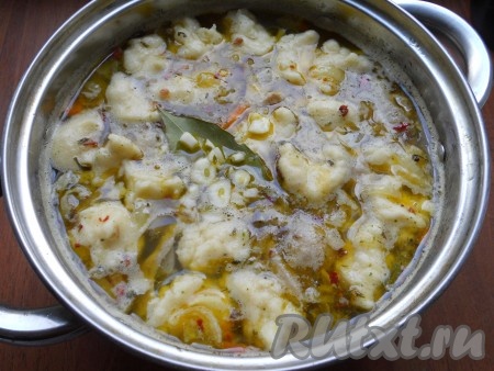 После того как куриный суп с картошкой, морковкой и луком с момента закипания проварится 5 минут, дать супу закипеть, от теста отщипывать руками небольшие кусочки (размер - на ваше усмотрение) и опускать их в кипящий суп. Также в куриный суп добавить лавровый лист и измельчённый чеснок. Когда галушки всплывут, значит суп готов. Выключить огонь, дать супу с курицей и галушками&nbsp;настояться под крышкой в течение минут 10.