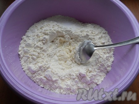 К просеянной муке, в углубление, добавить соль, растительное масло и влить немного воды. Ложкой немного перемешать.