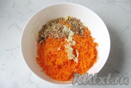 Чеснок почистить, помыть и также измельчить. Добавить в салатник к тертой моркови и грецким орехам.

