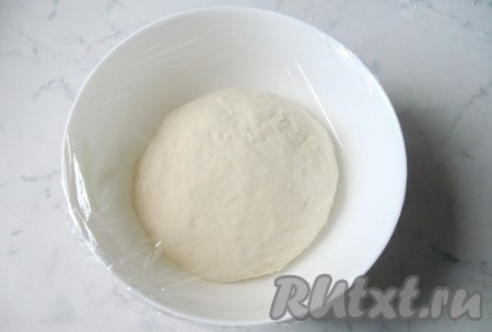 Затем выложить на стол, присыпанный мукой, и замесить мягкое, эластичное тесто, которое на ощупь должно быть, как мочка уха. Переложить тесто в миску, накрыть пищевой пленкой и поставить в теплое место.
