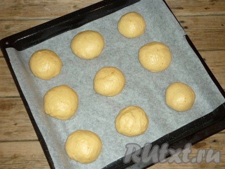 Сформировать круглые булочки и выложить на противень, застеленный пергаментной бумагой, на расстоянии друг от друга.&nbsp;
