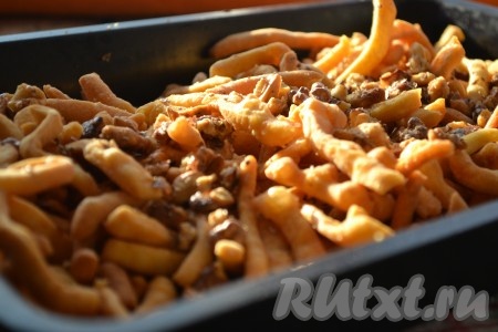 Орехи почистить, порубить (не очень мелко). В приготовленный сироп добавить орехи, перемешать. Жареные полоски теста выложить в достаточно объёмную ёмкость, залить медовым сиропом с орехами.