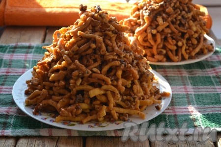 Очень аккуратно перемешать всю массу (не забывайте, что сироп горячий), а затем выложить на тарелку, формируя горку. Я перемешиваю вначале лопатками, а горку формирую руками, смоченными холодной водой. Очень важно всё делать не только аккуратно, но и быстро, пока сироп не остыл. В процессе формирования горки сильно не прижимайте кусочки теста.