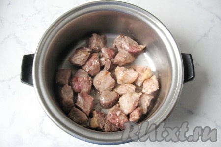 Обжарить свинину со всех сторон на достаточно сильном огне до румяной корочки со всех сторон. Переложить обжаренное мясо в достаточно глубокую кастрюлю с толстым дном.