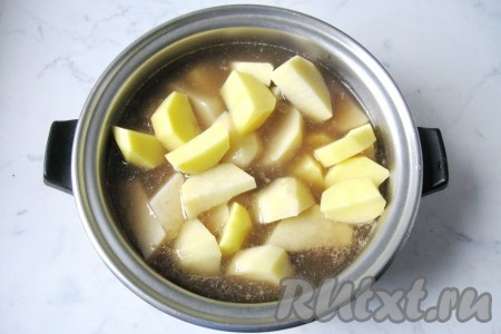 Когда мясо будет готово (станет достаточно мягким), почистить и помыть картофель, нарезать на кусочки. Нарезанную картошку вместе с лавровым листом добавить в кастрюлю со свининой и грибами, налить воду так, чтобы она на 2/3 покрывала картофель. Накрыть кастрюлю крышкой.