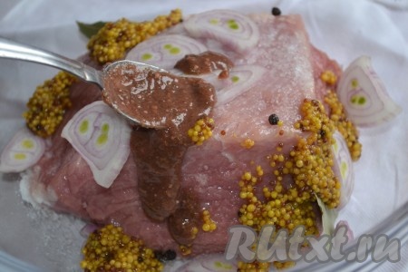 Лук очистить. Мясо натереть солью, молотым перцем и положить в глубокую миску. Добавить соус ткемали, горчицу, нарезанный кольцами лук и поломанные на небольшие кусочки лавровые листья. Тщательно обмазать свинину ткемали и горчицей со всех сторон.