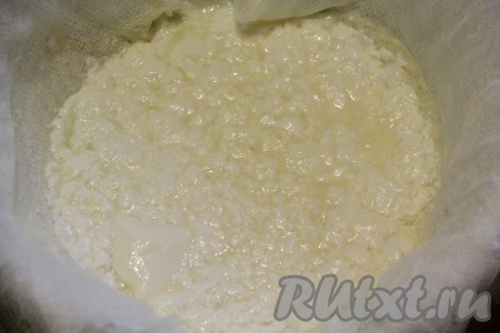 Затем снять кастрюлю с водяной бани, накрыть крышкой и дать немного остыть (до тёплого состояния). Дуршлаг выстелить марлей в три-четыре слоя. Затем аккуратно с помощью шумовки переложить творог на марлю. Кстати, из сыворотки можно испечь блинчики или хлеб.