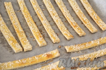 Поставить противень с сырно-овсяными палочками в разогретую духовку и выпекать минут 10 (до лёгкого золотистого цвета) при температуре 200 градусов. Готовые палочки достать из духовки, остудить на противне, а затем подать к столу.
