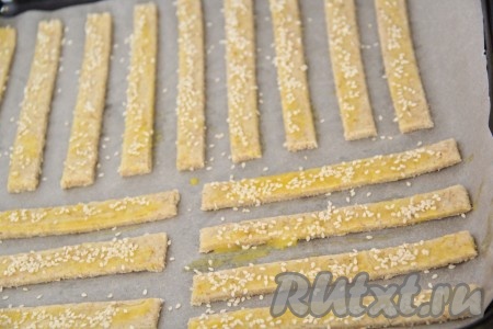  Смазать поверхность палочек яичным желтком и, по желанию, посыпать кунжутом.