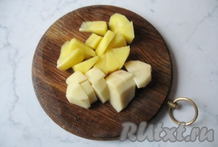 Картофель почистить, помыть и нарезать кубиками. Когда зелёная чечевица сварится, добавить картошку в кастрюлю с супом.
