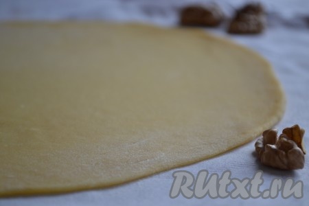 Каждый кусочек теста слегка присыпаем мукой и на посыпанной мукой поверхности раскатываем скалкой в тонкий круглый корж.