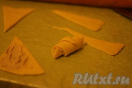 На каждый треугольник положить немного ореховой начинки и свернуть рогалик от основания к вершине. 