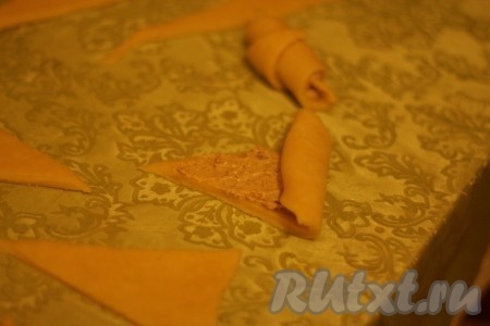 На каждый треугольник положить немного ореховой начинки и свернуть рогалик от основания к вершине. 