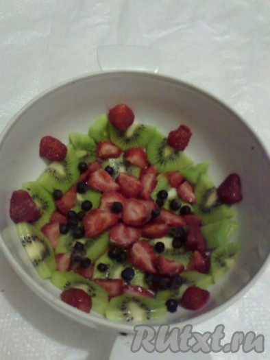 Далее в небольшую ёмкость всыпать желатин, залить 125 миллилитрами (половиной стакана) молока или чистой холодной воды и оставить минут на 30, чтобы желатин набух. Сметану поместить в миску, добавить сахар и взбить миксером до полного растворения сахара. Набухший желатин поставить на водяную баню и, помешивая,&nbsp; довести его до полного растворения, не давая ему закипеть. Не переставая взбивать сметану с сахаром, тонкой струйкой влить желатин, взбивать сметанный крем ещё около полминуты. Дно глубокой миски (у меня - супница) застелить пищевой плёнкой (я не застилала, но лучше застелить). Фрукты и ягоды вымыть, очистить от кожуры и косточек, яблоки и клубнику нарезать на мелкие кусочки, киви нарезать на кружочки или полукружочки (немного оставить для украшения верха торта). Бисквит тоже нарезать на кусочки размером 1,5х1,5 сантиметра. Выложить киви и клубнику (или другие ягоды, например, смородину, чернику) на дно и бока миски.